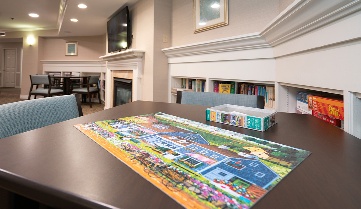 table with a colorful puzzle spread out on it, accompanied by a single chair nearby.